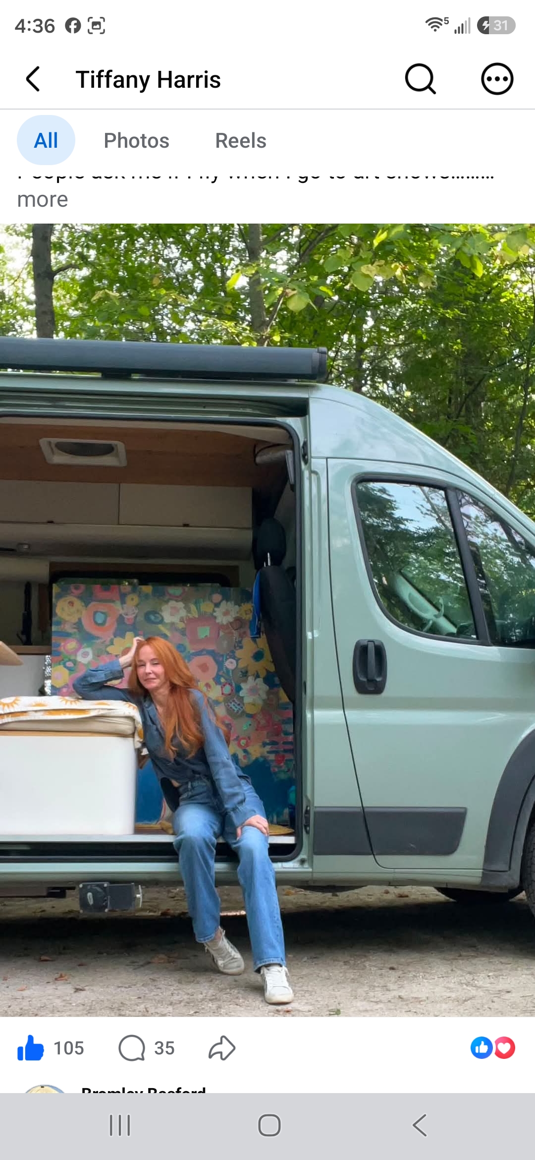 Artist Tiffany Harris sitting in the open doorway of her van with artwork packed behind her
